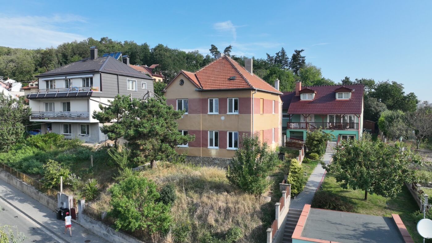 Fotografie původního stavu staršího rodinného domu se sedlovou střechou a břízami před plánovanou rekonstrukcí.